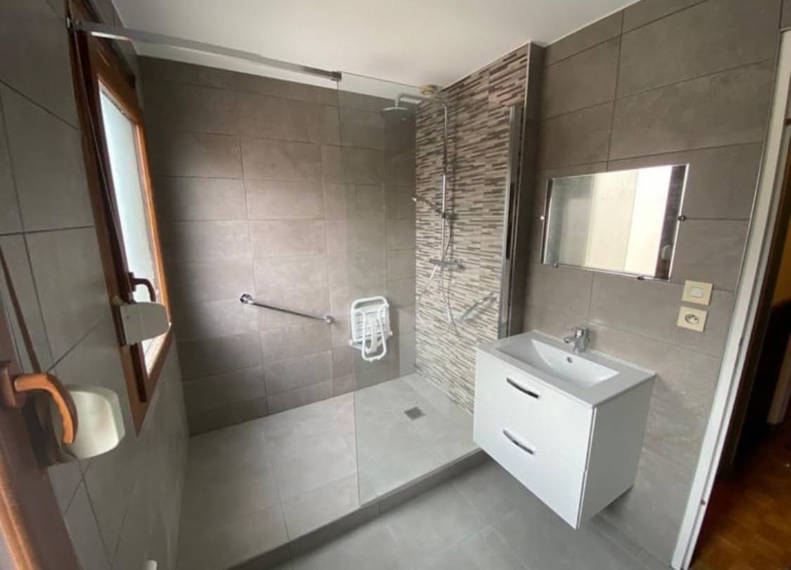 Vue détaillée des équipements PMR et du carrelage antidérapant dans une salle de bain rénovée à Colmar.