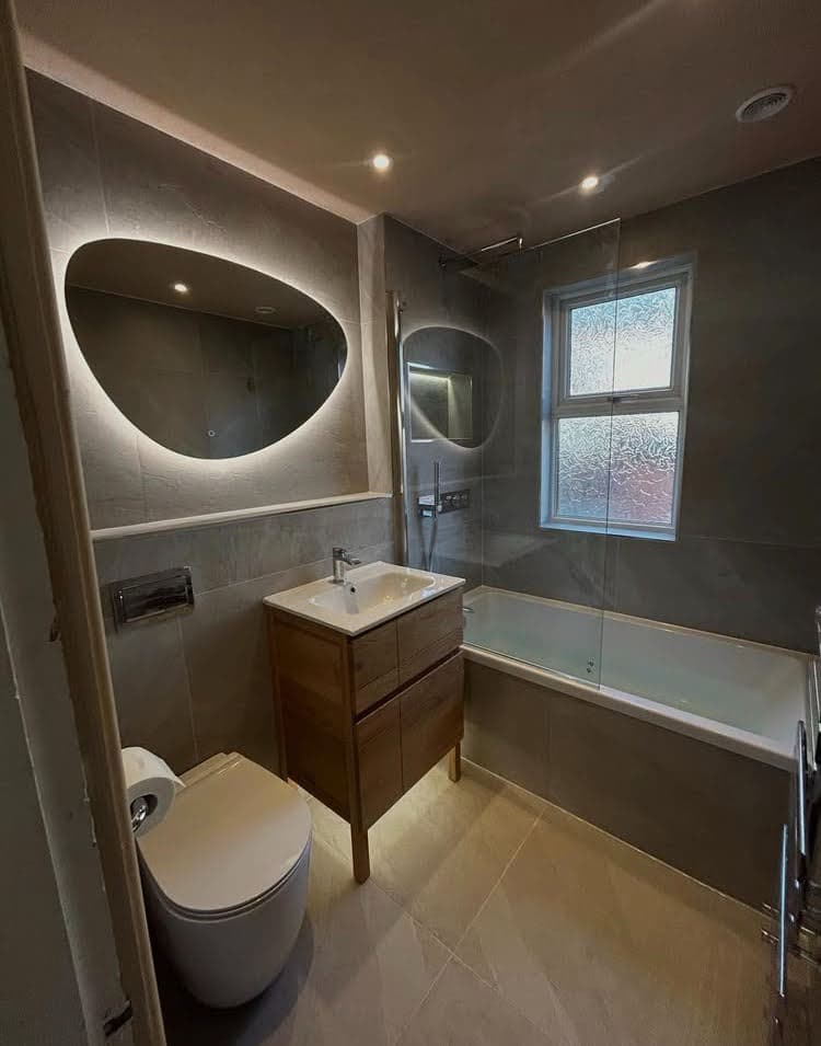 Résultat final d'une rénovation clé en main d'une salle de bain à Illkirch-Graffenstaden avec meuble bois et carrelage minéral.