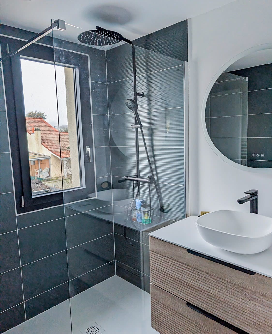 Création d'une douche spacieuse avec faïence anthracite, paroi en verre trempé et colonne de douche noire mate lors d'une installation de salle de bain clé en main à Molsheim.