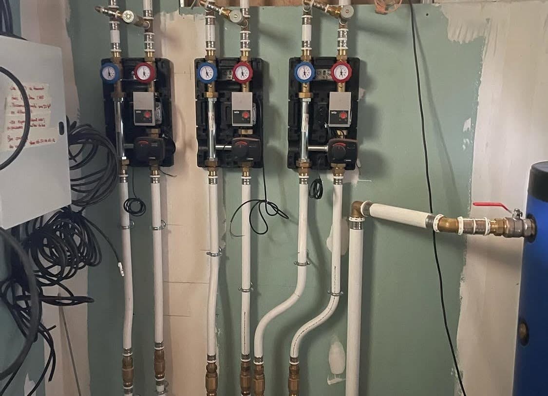 Fixation murale de trois modules intérieurs Daikin sur des plaques hydrofuges, constituant le cœur d'une nouvelle chauffagerie par un plombier chauffagiste dans le Bas-Rhin.
