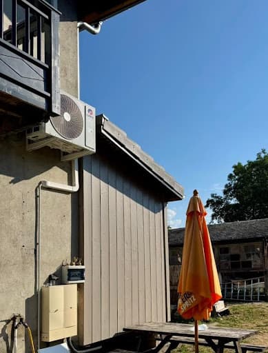Unité extérieure de marque GREE fixée sur un support mural anti-vibratile sous un balcon, lors d'une installation de climatisation réversible à Saverne dans le Bas-Rhin.