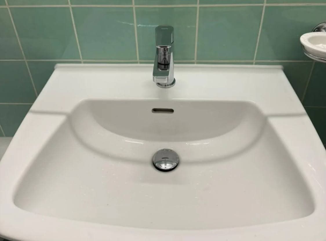 Lavabo avec mitigeur chromé neuf et joint silicone blanc impeccable réalisé par un plombier à Schiltigheim dans le Bas-Rhin.