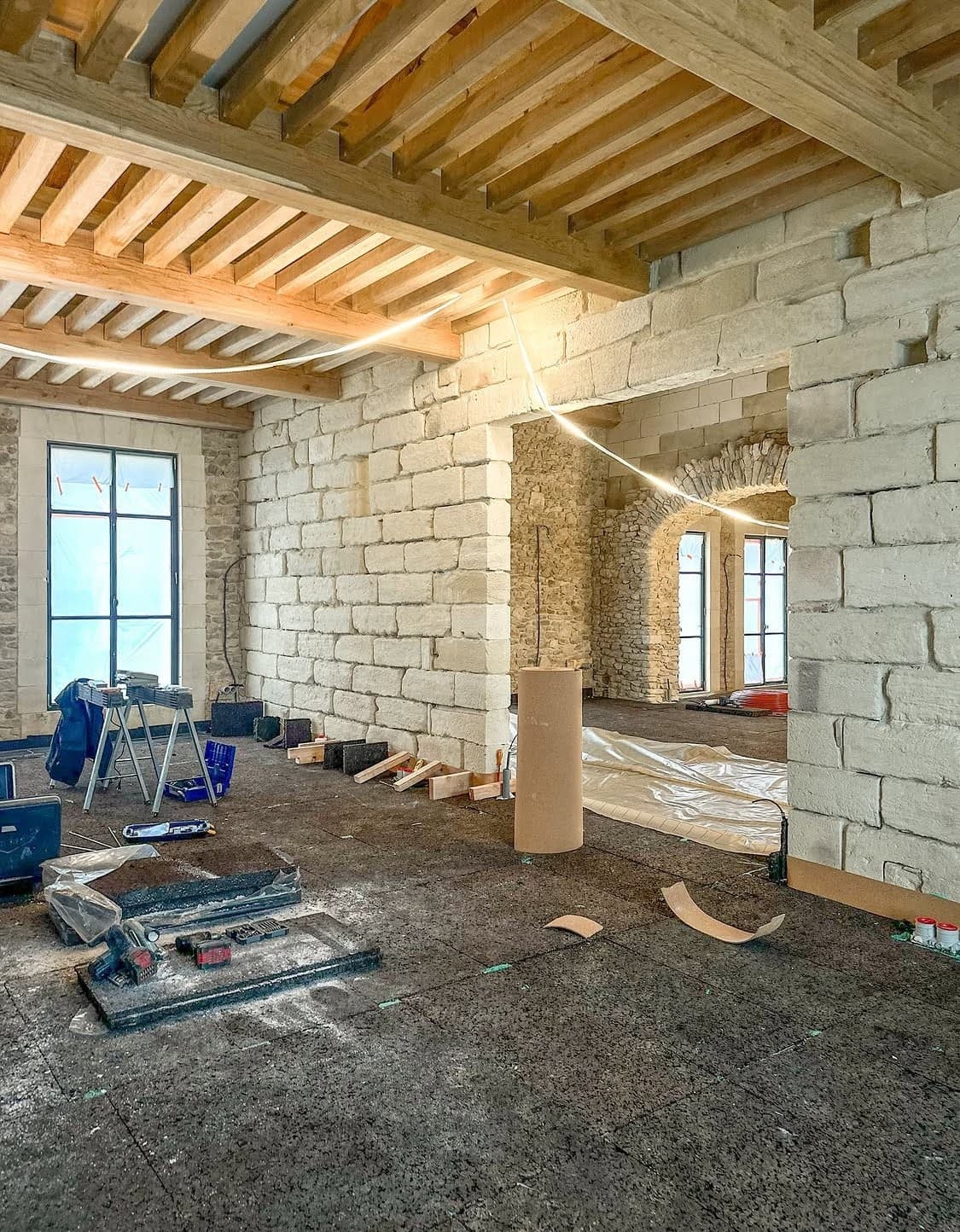 Phase préparatoire de l'installation d'un chauffage au Sol à Sélestat avec la pose de plaques d'isolation thermique et phonique noires sur la dalle brute du bâtiment ancien.