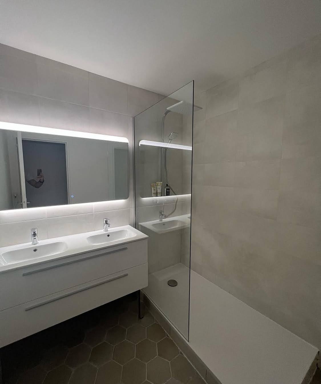 Superbe résultat final d'une rénovation salle de bain à Sélestat avec installation d'une douche sur mesure, pose d'un sol en tomettes hexagonales et d'un meuble vasque suspendu.