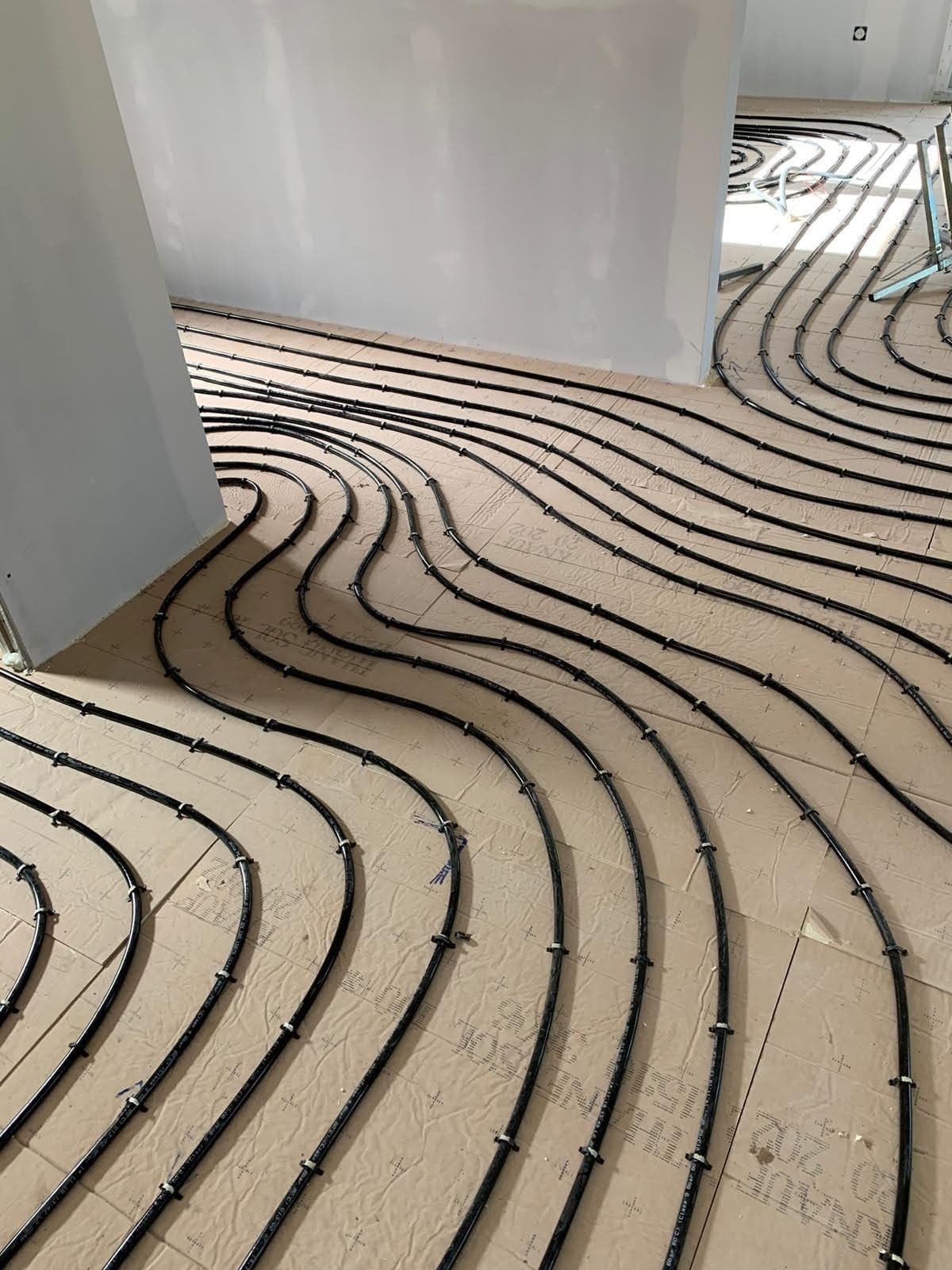 Agencement sur mesure et cintrage des boucles de chauffage au sol autour des cloisons intérieures, démontrant l'expertise d'un chauffagiste Strasbourg.