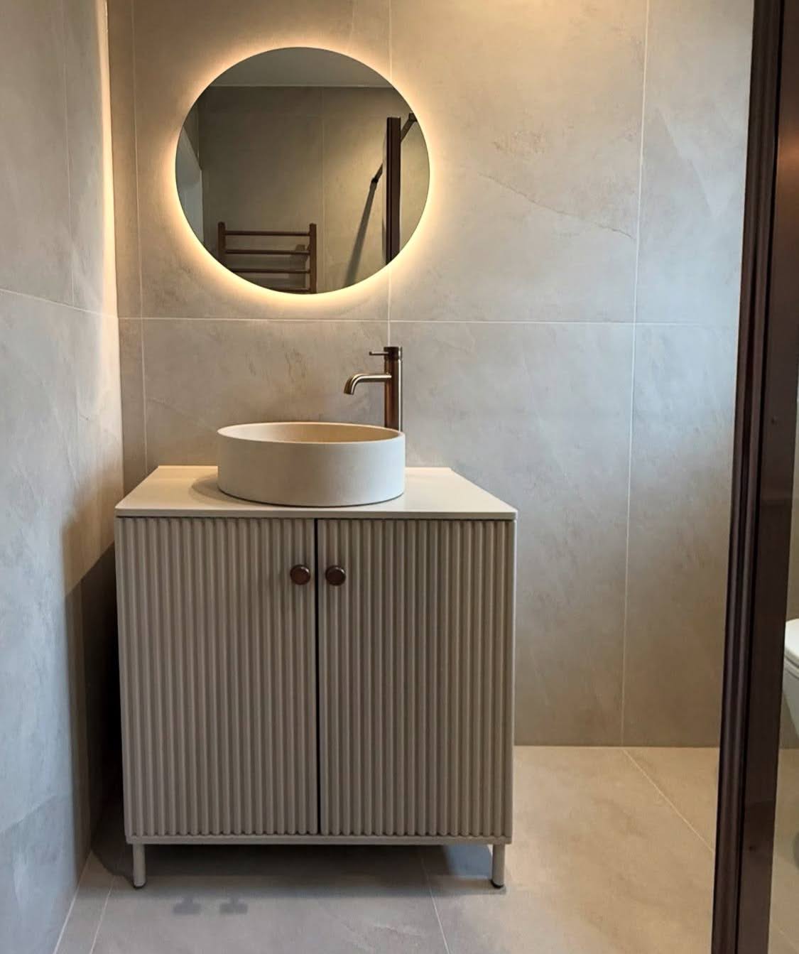 Détail d'une rénovation salle de bain à Bischheim avec un meuble sous-vasque aux façades nervurées, une vasque à poser et un miroir rétroéclairé LED.