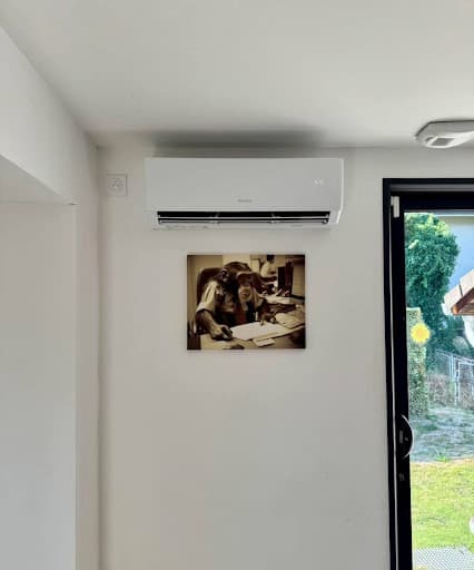 Unité intérieure murale de type split installée au-dessus d'un cadre décoratif, garantissant le rafraîchissement et le chauffage grâce à une climatisation réversible à Saverne.