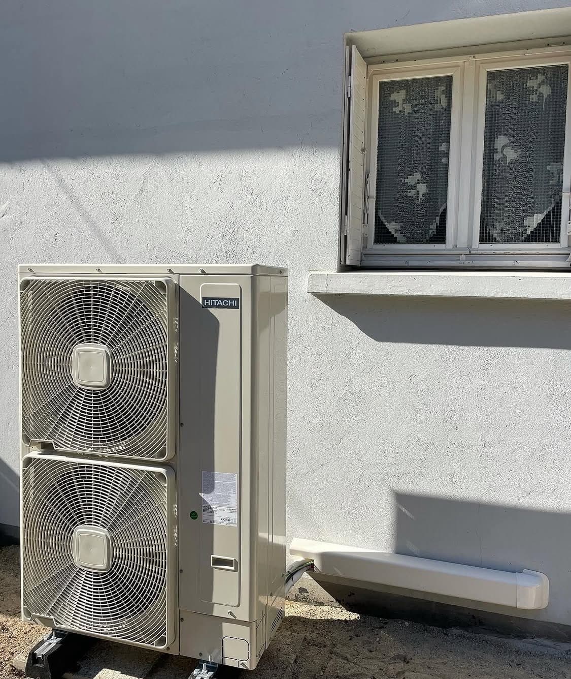 Unité extérieure Hitachi installée en façade lors d'un remplacement de chaudière à Schiltigheim pour une efficacité énergétique maximale.